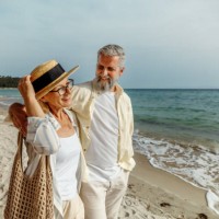 casually clothed mature couple enjoying walk by the sea together - travel stock pictures, royalty-free photos & images