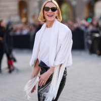 Cate Blanchett wears black sunglasses, white board shoulder draped Louis Vuitton top, shiny black wrapped Louis Vuitton leather pants, outside Louis...