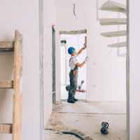 caucasian construction worker checking the level measurements inside an apartment - home decoration stock pictures, royalty-free photos & images