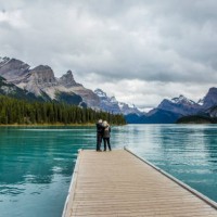 caucasian couple standing at the end of dock on mountain lake - travel stock pictures, royalty-free photos & images