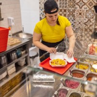 caucasian female fast food worker, making burrito - junk food stock pictures, royalty-free photos & images
