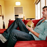 caucasian man eating take out food on sofa - junk food stock pictures, royalty-free photos & images