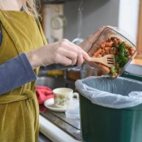 caucasian woman adding vegetable remains to compost bin - food stock pictures, royalty-free photos & images