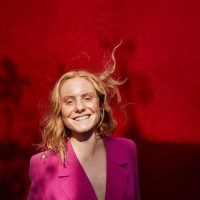 caucasian woman standing against red wall - fashion stock pictures, royalty-free photos & images