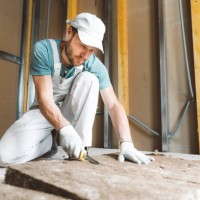 caucasian worker cutting mineral rock wool on construction site - home decoration stock pictures, royalty-free photos & images