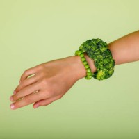 celebrating veganism: woman hand wearing a broccoli bracelet, symbolizing a commitment to a healthy lifestyle and unity with nature in green studio - fashion stock pictures, royalty-free photos & images