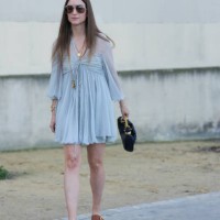 Charlotte Groeneveld wears dark brown sunglasses, gold layered Chloe necklaces, light blue sheer mesh short sleeve Chloe mini dress, gold bracelets,...