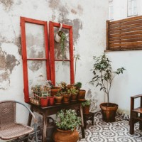 charming patio with a variety of potted plants and vintage furniture on patterned tiles. - garden decoration stock pictures, royalty-free photos & images