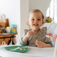 cheerful baby girl eating meal with mother - food stock pictures, royalty-free photos & images
