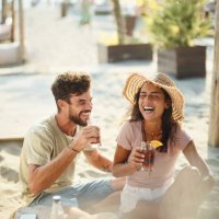 cheerful couple having fun in a beach café. - travel stock pictures, royalty-free photos & images