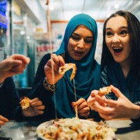 cheerful female friends eating at cafe - food photos et images de collection