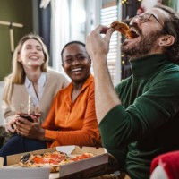 cheerful friends hanging out at home and eating pizza - junk food stock pictures, royalty-free photos & images