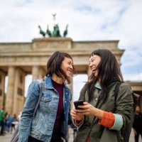 cheerful friends standing against brandenburg gate - travel stock pictures, royalty-free photos & images