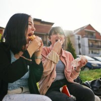 cheerful hipster friends eating fast food outdoors - junk food stock pictures, royalty-free photos & images