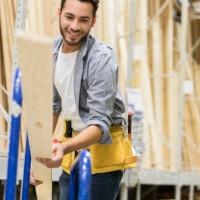 cheerful lumber yard worker loads planks on a dolly - home decoration stock pictures, royalty-free photos & images