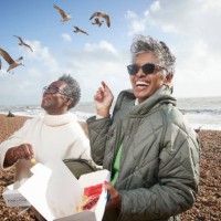 cheerful male and female friends having french fries - travel stock pictures, royalty-free photos & images