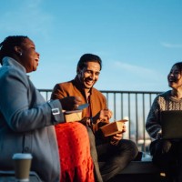 cheerful multi-ethnic business people sitting and having takeaway lunch at rooftop garden at top of office building during lunch break - junk food stock pictures, royalty-free photos & images