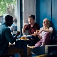 cheerful multi ethnic group of friends having a breakfast togetherâ in a cafe - coffee stock pictures, royalty-free photos & images
