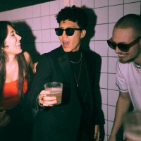 cheerful non-binary person enjoying dance with friends against wall at nightclub - concert stock pictures, royalty-free photos & images