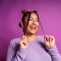 cheerful plus size woman playing with hair on purple background - fashion stock pictures, royalty-free photos & images