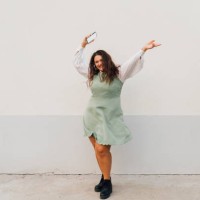 cheerful plus size woman with smart phone dancing against wall - fashion stock pictures, royalty-free photos & images