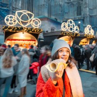 cheerful woman eating a pastry dough at christmas markets, vienna, austria - junk food stock pictures, royalty-free photos & images