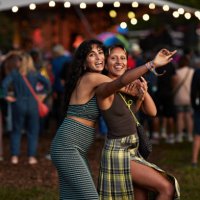 cheerful woman hugging female friend at concert - concert stock pictures, royalty-free photos & images