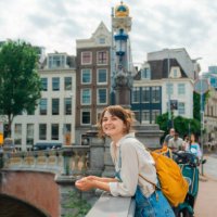cheerful woman walking in amsterdam in summer - travel stock pictures, royalty-free photos & images