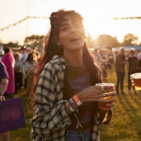 cheerful woman with beer glass at music festival - concert stock pictures, royalty-free photos & images