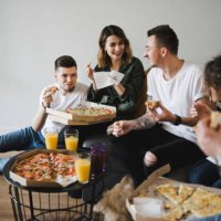 cheerful young friends eating fresh pizza. - junk food stock pictures, royalty-free photos & images