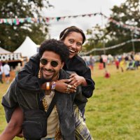 cheerful young man giving piggyback to girlfriend - concert stock pictures, royalty-free photos & images