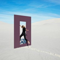 cheerful young woman jumping through door frame at desert - fashion stock pictures, royalty-free photos & images