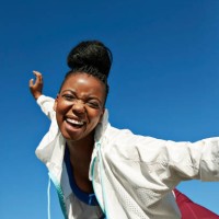 cheerful young woman with hair bun against clear sky during sunny day - fashion stock-fotos und bilder