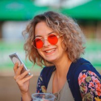 cheerful young woman with red sunglasses and phone - concert stock pictures, royalty-free photos & images
