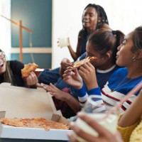 cheerful young women eating fresh pizza - junk food stock pictures, royalty-free photos & images