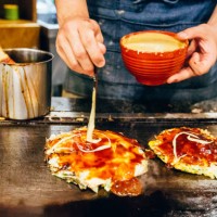 chef cooking okonomiyaki at japanese restaurant - junk food stock pictures, royalty-free photos & images