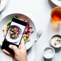 chef taking photograph of vegan falafel bowl on table. - food stock pictures, royalty-free photos & images
