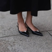 Cherifa Akili seen wearing Arket black oversized silk midi skirt and YSL black varnished leather ballet flats, during the Womenswear Fall/Winter...