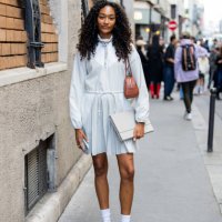 Cheyenne Maya Carty wears brown bag, white dress with zipper long sleeves outside Lacoste during Womenswear Spring/Summer 2025 as part of Paris...
