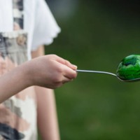 child (6-7) balancing a painted green easter egg on a spoon - garden decoration stock pictures, royalty-free photos & images