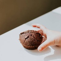 child's hand reaching for a chocolate chip bun - junk food stock pictures, royalty-free photos & images