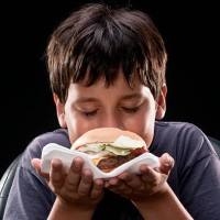 child smelling a hamburger - junk food stock pictures, royalty-free photos & images