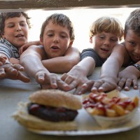 children (6-10) at fastfood vendor's window, reaching for plate - junk food stock pictures, royalty-free photos & images