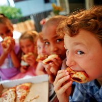 children eating pizza outdoors - junk food stock pictures, royalty-free photos & images