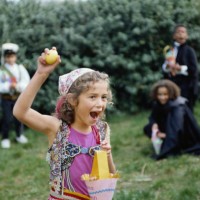 children in costumes hunting for eggs - garden decoration stockfoto's en -beelden