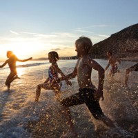 children running into sea at sunset - travel photos et images de collection