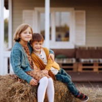 children sit on the hay in the yard decorated with pumpkins for halloween. - garden decoration stock pictures, royalty-free photos & images