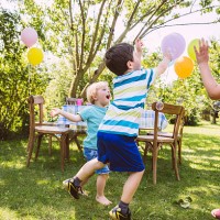children trying to catch soap bubbles in garden - garden decoration stock pictures, royalty-free photos & images