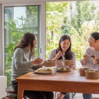 chinese mother, eurasian daughters eating vegan takeout in re-useable containers - junk food stock pictures, royalty-free photos & images