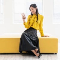 chinese woman on yellow bench with phone - fashion stock pictures, royalty-free photos & images